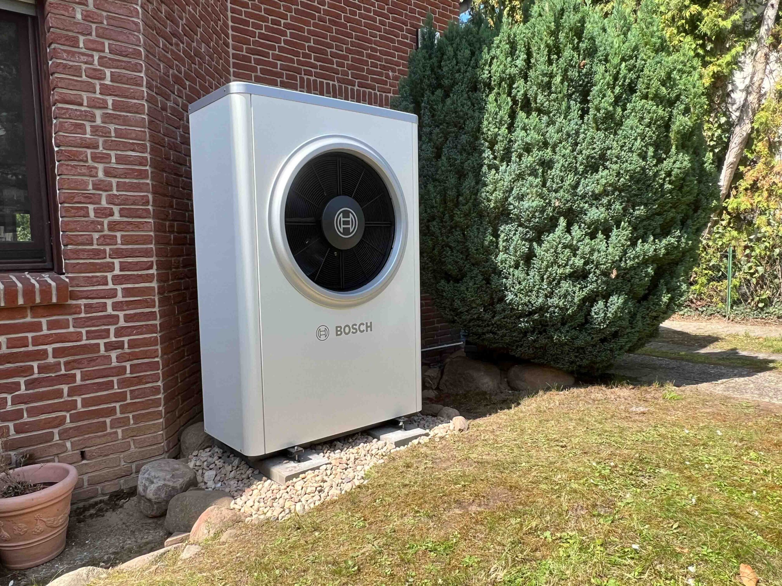 Bosch Luft-Wasser-Wärmepumpe Außengerät im Garten eines Einfamilienhauses in Berlin nach energetischer Sanierung