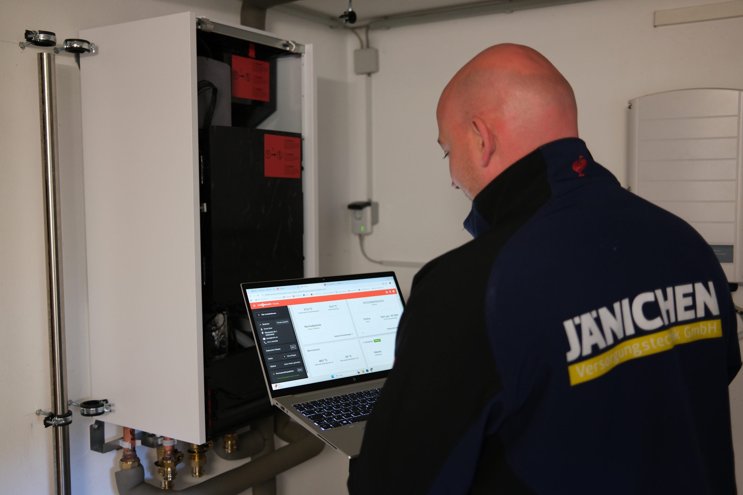 Jänichen Techniker nimmt eine Heizungsanlage mit Laptop in Betrieb